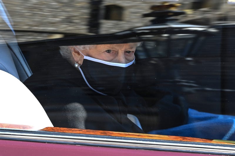 Britain's Queen Elizabeth II follows the coffin in a car as it makes it's way past the Round Tower during the funeral of Britain's Prince Philip inside Windsor Castle in Windsor, England Saturday April 17, 2021