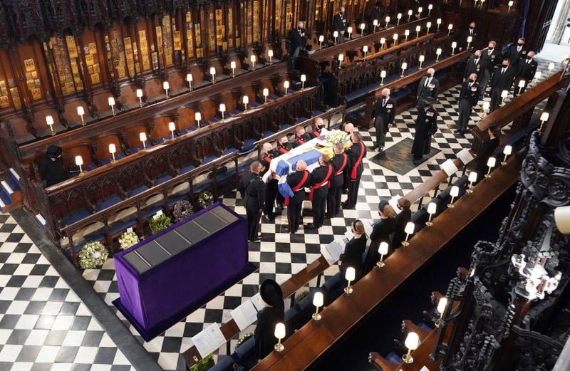 Britain's Queen Elizabeth watches as pallbearers carry the coffin of the Duke of Edinburgh during his funeral at St George's Chapel in Windsor Castle, Windsor, England, Saturday April 17, 2021.