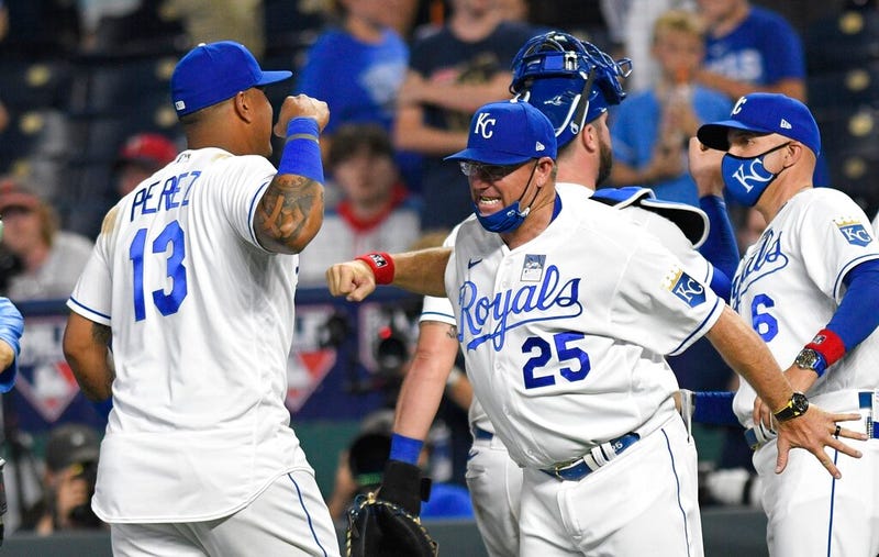 Kansas City Royals' Salvador Perez (13) is congratulated by third base coach Vance Wilson (25) 