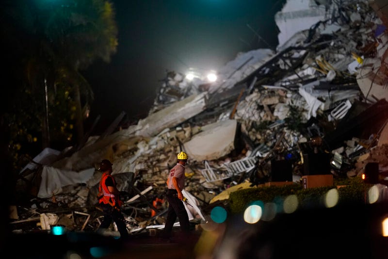 Rescue workers walk beside the rubble as rescue efforts continue where a wing of a 12-story beachfront condo building collapsed, Thursday, June 24, 2021, in the Surfside area of Miami.