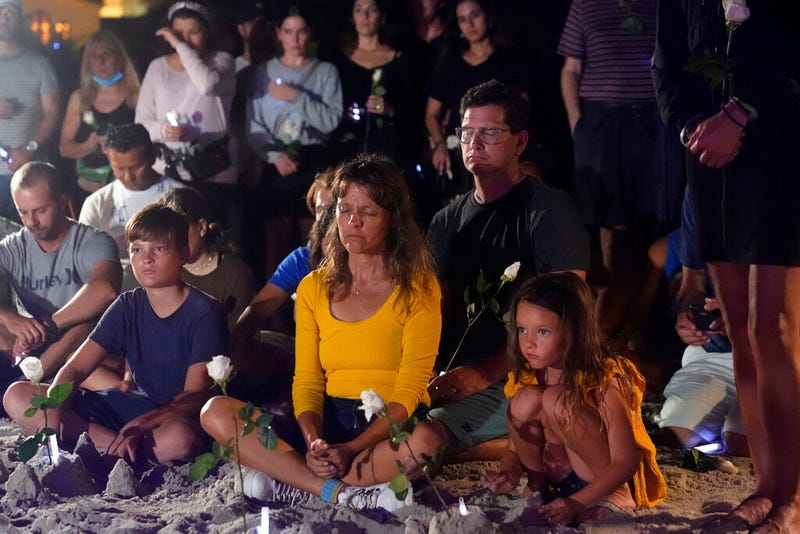 People gather at a vigil, late Monday, June 28, 2021, in Surfside, Fla. The vigil remembered those that died, are missing and those injured after a residential building collapsed last Thursday.