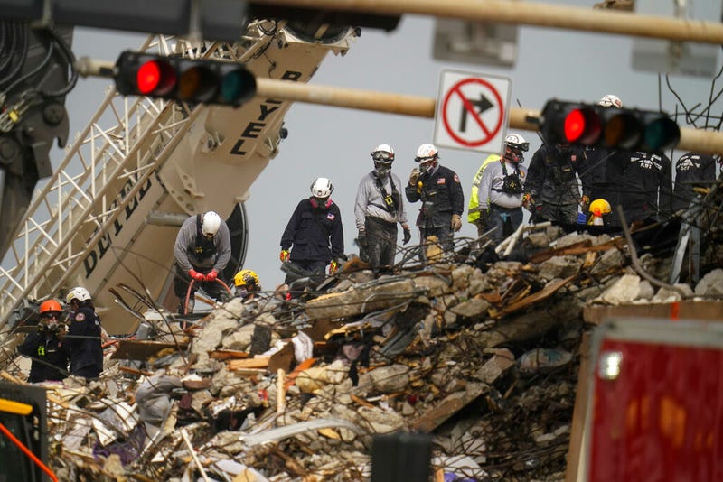 Search and rescue personnel work atop the rubble at the Champlain Towers South condo building, where scores of people remain missing almost a week after it partially collapsed, Wednesday, June 30, 2021, in Surfside, Fla. (AP Photo/Gerald Herbert)