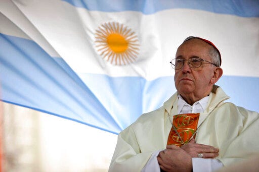 Then-Argentina's Cardinal Jorge Bergoglio gives a Mass outside the San Cayetano church where an Argentine flag hangs behind in Buenos Aires, Argentina, Aug. 7, 2009.