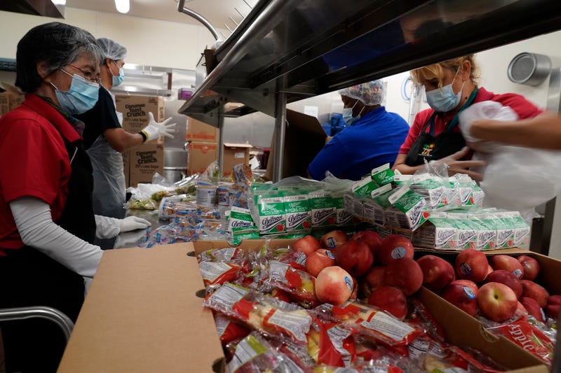 Los Angeles Unified School District food service workers from left, Tomoko Cho, Aldrin Agrabantes, April Thomas, and Marisel Dominguez, pre-package hundreds of free school lunches in plastic bags on Thursday, July 15, 2021, at the Liechty Middle School in Los Angeles. Flush with cash from an unexpected budget surplus, California is launching the nation's largest statewide universal free lunch program. When classrooms open for the fall term, every one of California's 6.2 million public school students will have the option to eat school meals for free, regardless of their family's income. (AP Photo/Damian Dovarganes)