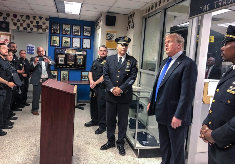 Former President Donald Trump, second from right, commemorated the 20th anniversary of the Sept. 11 attacks by visiting the NYPD's 17th police precinct in New York, where he criticized President Biden over the pullout from Afghanistan, Saturday Sept. 11, 2021