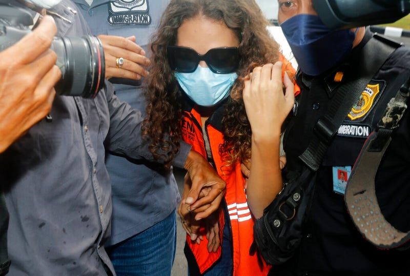 Heather Mack of Chicago, Ill., center, escorted by Indonesian immigration officers to Immigration detention center in Jimbaran, Bali, Indonesia on Friday, Oct. 29, 2021. The American woman convicted of helping to kill her mother on Indonesia's tourist island of Bali in 2014 walked free from prison Friday after serving seven years of a 10-year sentence and will be deported to the United States.