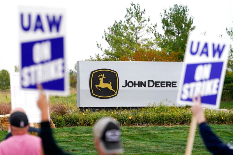 Members of the United Auto Workers strike outside of a John Deere plant