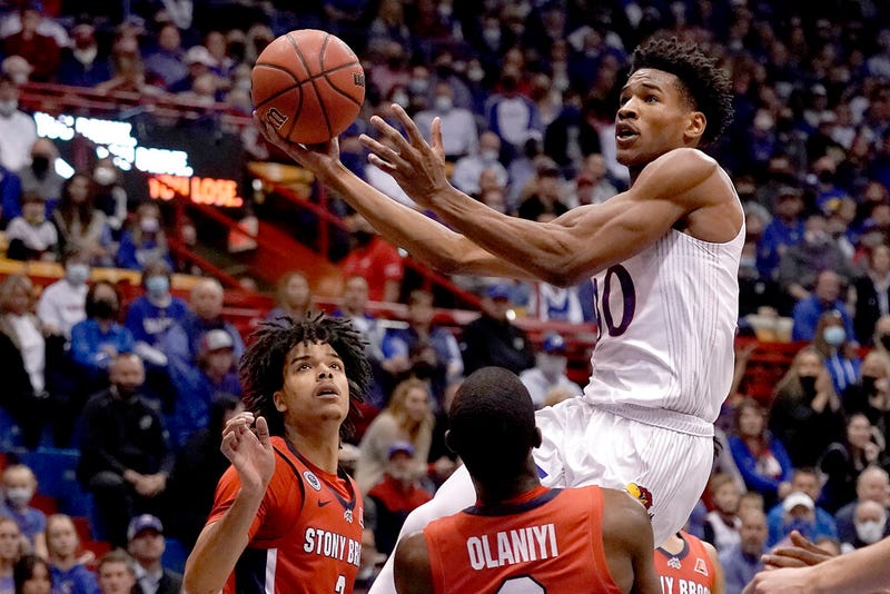 Kansas's Ochai Agbaji shoots over Stony Brook's Elijah Olaniyi and Frankie Policelli