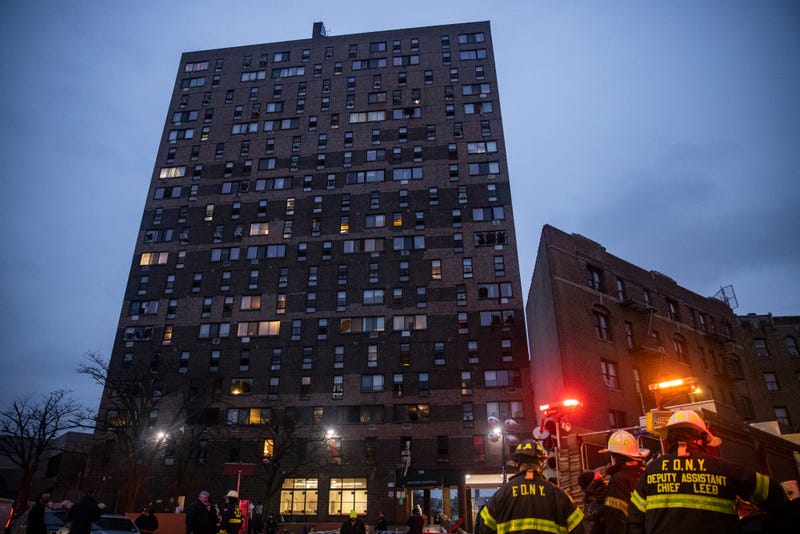 Emergency personnel work at the scene of a fatal fire at an apartment building in the Bronx on Sunday, Jan. 9, 2022, in New York