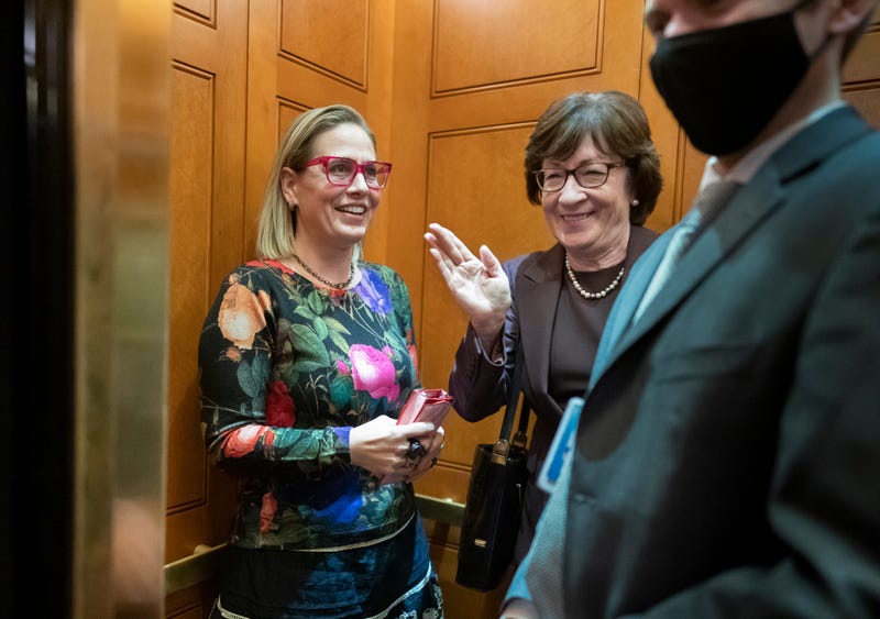 Sen. Kyrsten Sinema, D-Ariz., left, and Sen. Susan Collins, R-Maine, board the elevator outside the Senate after voting on an appropriations bill that funds the government through Feb. 18 at the Capitol in Washington, on Dec. 2, 2021.