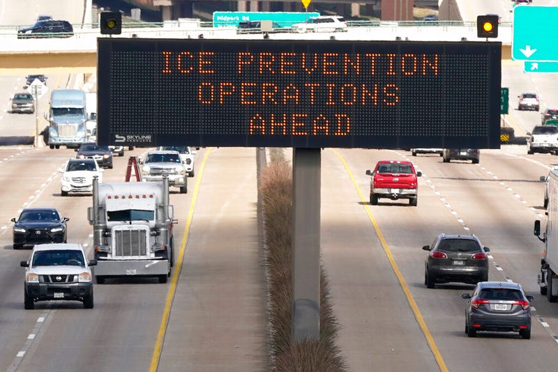 A street sign warns drivers of ice prevention operations on highways ahead of winter weather in Dallas