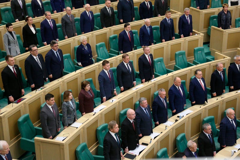 In this photo provided by the Federation Council of the Federal Assembly of the Russian Federation, lawmakers of Federation Council of the Federal Assembly of the Russian Federation listen to the national anthem as they attend a session in Moscow, Russia, Tuesday, Feb. 22, 2022