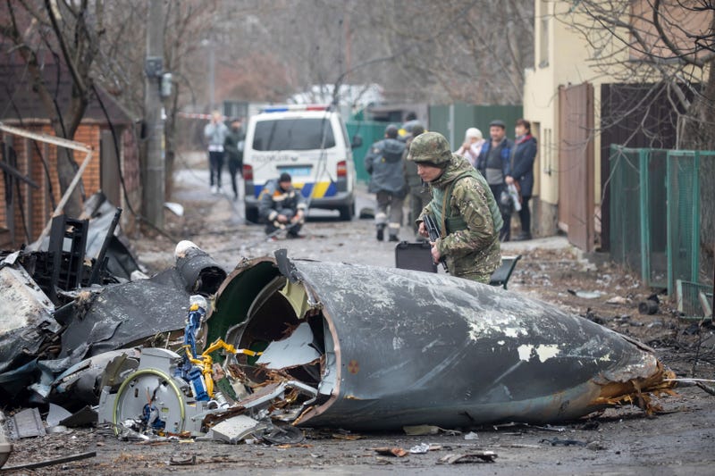 A Ukrainian Army soldier inspects fragments of a downed aircraft in Kyiv, Ukraine, Friday, Feb. 25, 2022