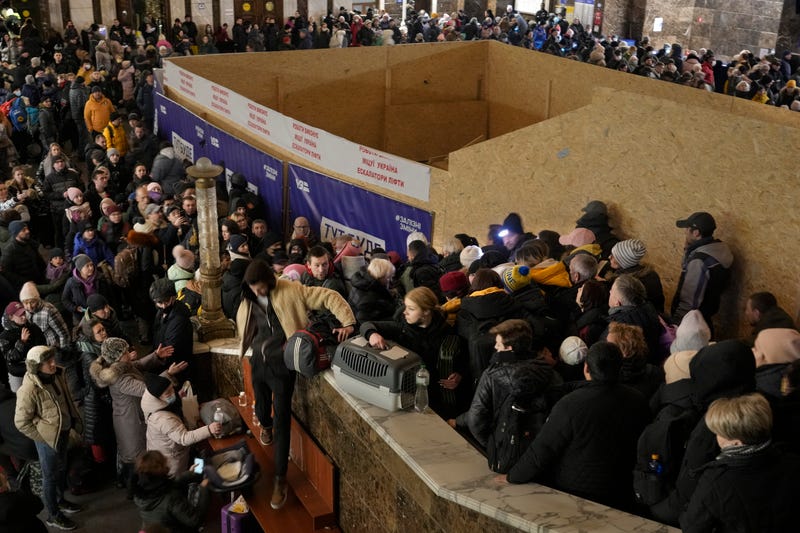 People struggle on stairways after a last minute change of the departure platform for a Lviv bound train in Kyiv, Ukraine, Monday, Feb. 28, 2022