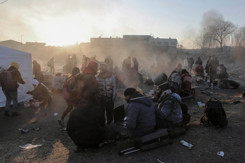 Refugees try to stay warm after fleeing the Russian invasion of Ukraine, at the Medyka border crossing in Poland, Tuesday, March 1, 2022
