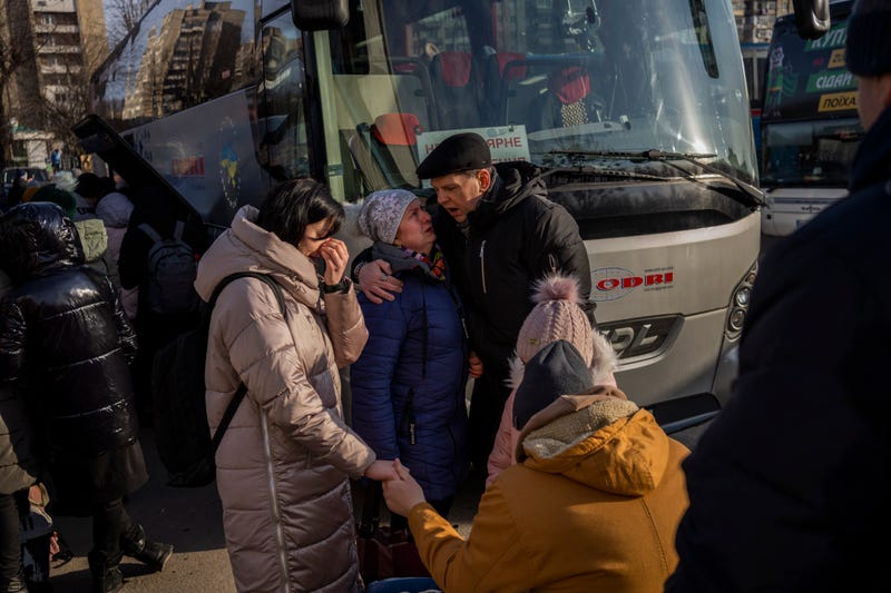 Ukrainian families say goodbye as they prepare to board a bus to Poland at Lviv bus main station, western Ukraine, Tuesday, March 1, 2022