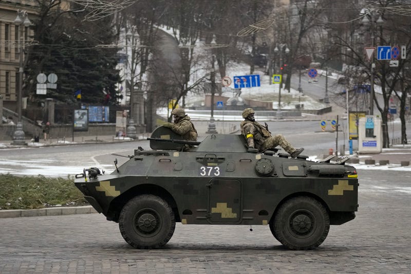 Ukrainian servicemen ride on top of an armored personnel carrier speeding down a deserted boulevard during an air raid alarm, in Kyiv, Ukraine, Tuesday, March 1, 2022
