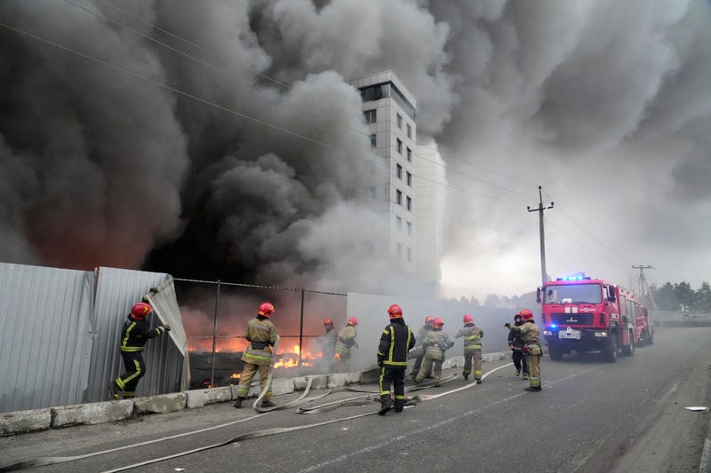 Firefighters work to extinguish a fire at a damaged logistic center after shelling in Kyiv, Ukraine, Thursday, March 3, 2022