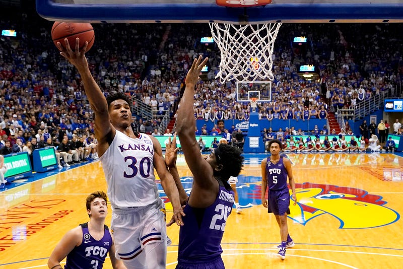 Kansas guard Ochai Agbaji (30) gets past TCU center Souleymane Doumbia (25) to put up a shot