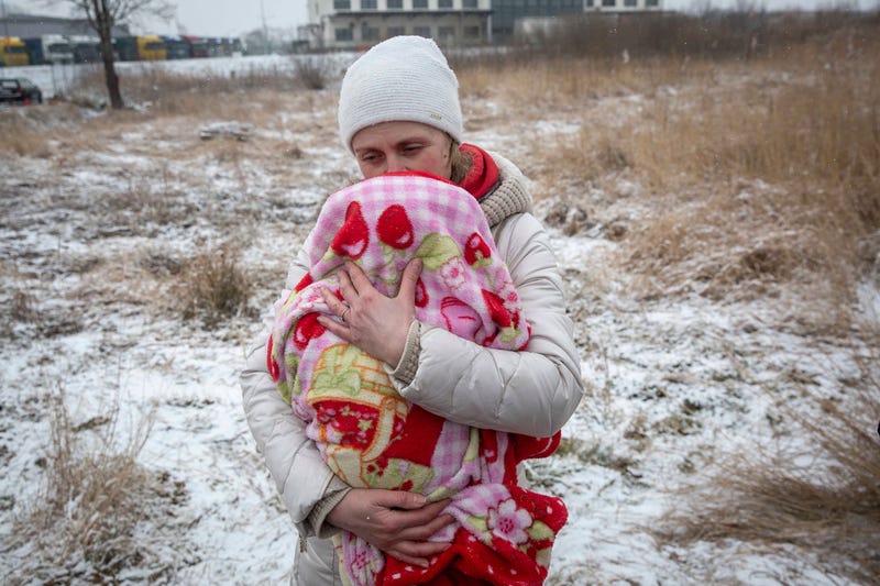 Axana Opalenko, 42, holds Meron, 2 months old, in an effort to warm him after fleeing from Ukraine, at the border crossing in Medyka, Poland, Wednesday, March 9, 2022