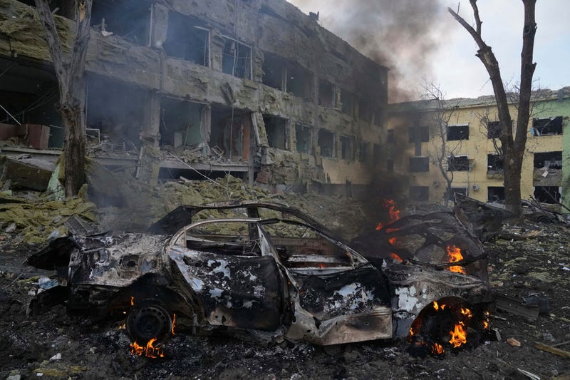 A car burns at the side of the damaged by shelling maternity hospital in Mariupol, Ukraine, Wednesday, March 9, 2022