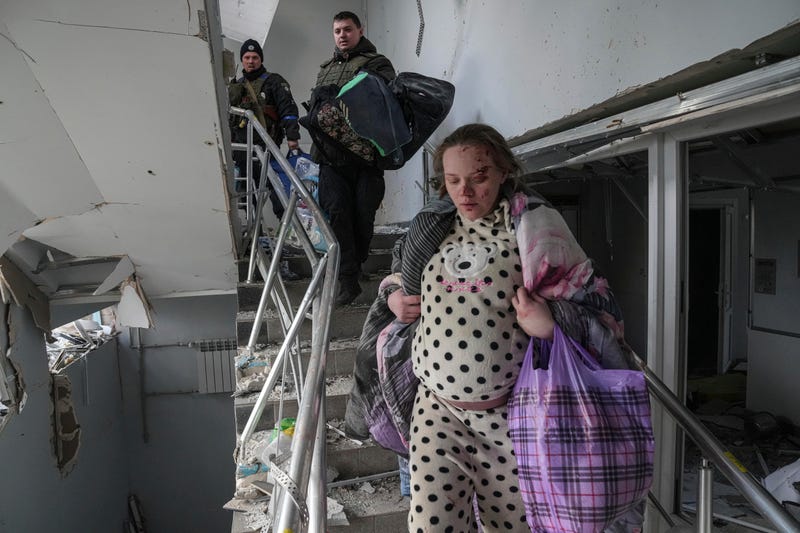 An injured pregnant woman walks downstairs in the damaged by shelling maternity hospital in Mariupol, Ukraine, Wednesday, March 9, 2022