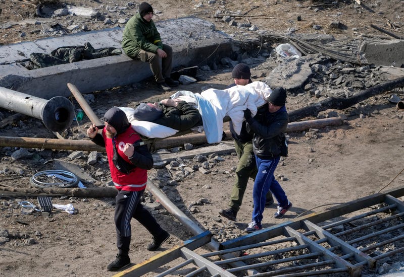 Volunteers evacuate an elderly resident in Irpin