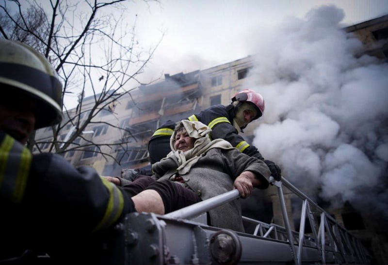 In this photo released by Ukrainian State Emergency Service press service, firefighters evacuate an elderly woman from an apartment building hit by shelling in Kyiv, Ukraine, Monday, March 14, 2022
