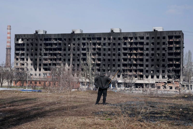 A man looks at a burned apartment building that was damaged by shelling in Mariupol, Ukraine, Sunday, March 13, 2022