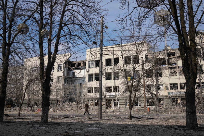 A man walks past a building that was damaged by shelling in Mira Avenue (Avenue of Peace) in Mariupol, Ukraine, Sunday, March 13, 2022