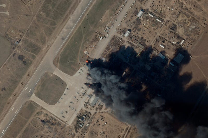 In this satellite picture provided by Planet Labs PBC, fire and smoke is seen at Kherson International Airport and Air Base in Kherson, Ukraine, Tuesday, March 15, 2022. A suspected Ukrainian strike on the air base damaged Russian helicopters and vehicles Tuesday