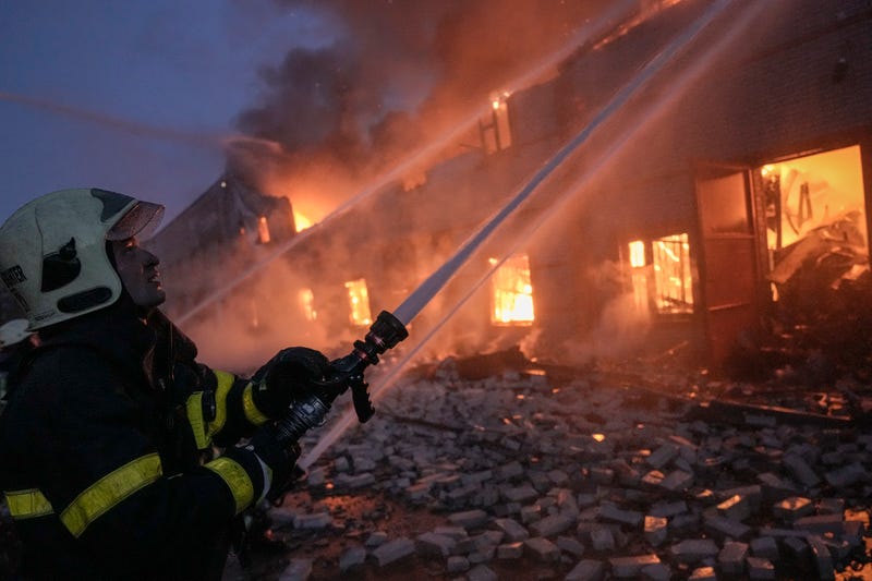 FILE - Ukrainian firefighters extinguish a blaze at a warehouse after a bombing on the outskirts of Kyiv, Ukraine, Thursday, March 17, 2022. Russian forces destroyed a theater in Mariupol where hundreds of people were sheltering Wednesday and rained fire on other cities, Ukrainian authorities said, even as the two sides projected optimism over efforts to negotiate an end to the fighting.