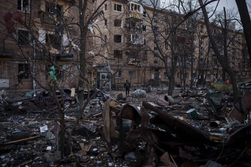 A police officer walks at the site of a bombing that damaged residential buildings in Kyiv, Ukraine, Friday, March 18, 2022