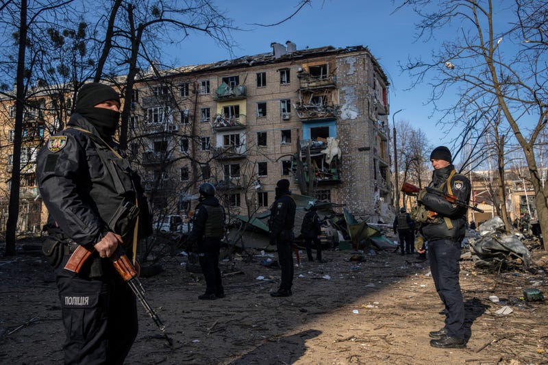 Policemen stand guard at the site where a bombing damaged residential buildings in Kyiv, Ukraine, Friday, March 18, 2022