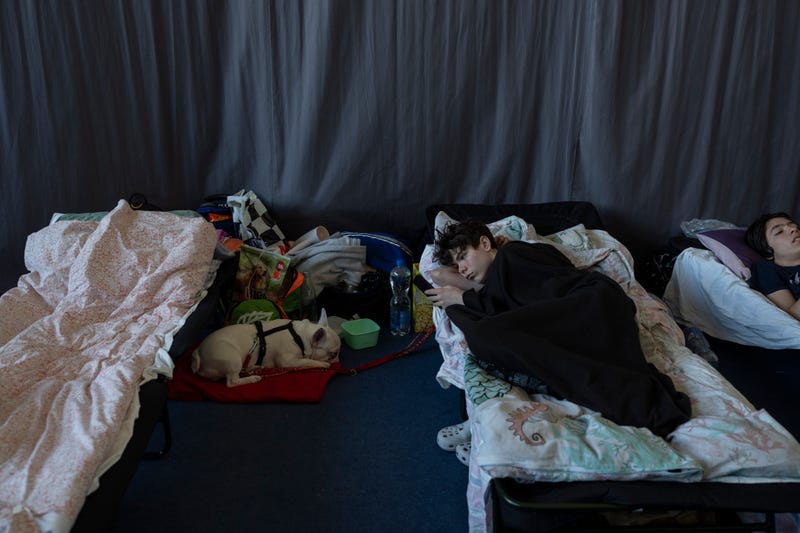 People who fled the war in Ukraine rest inside an indoor sports stadium of a high school in Przemysl, southeastern Poland, on Friday March 18, 2022.