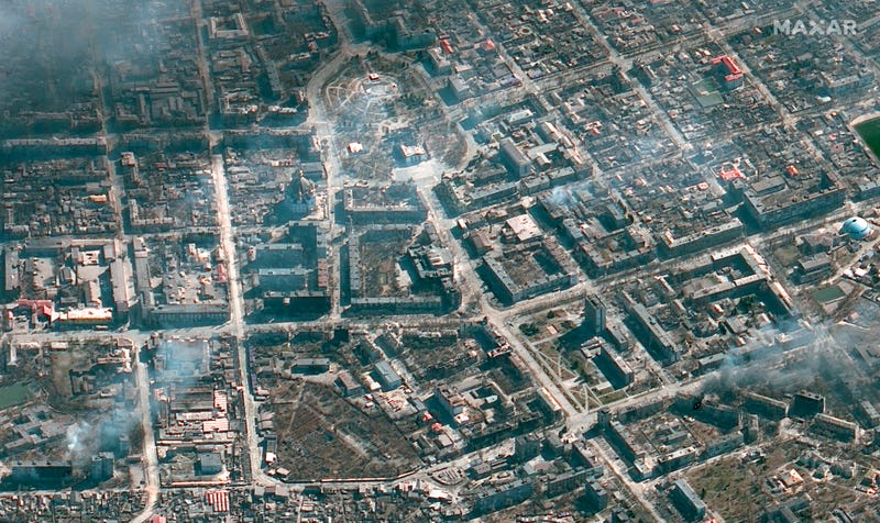 This satellite image provided by Maxar Technologies on Monday, March 21, 2022 shows the damaged Mariupol Drama theater, top center, and the area around it in Mariupol, Ukraine