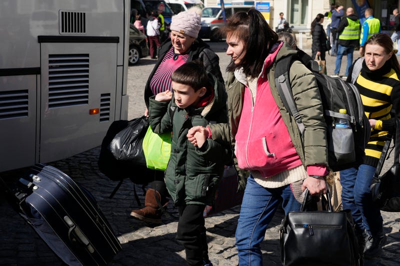 Ukrainian refugees with children board transport at a square next to a railway station in Przemysl, Poland, on Tuesday, March 22, 2022