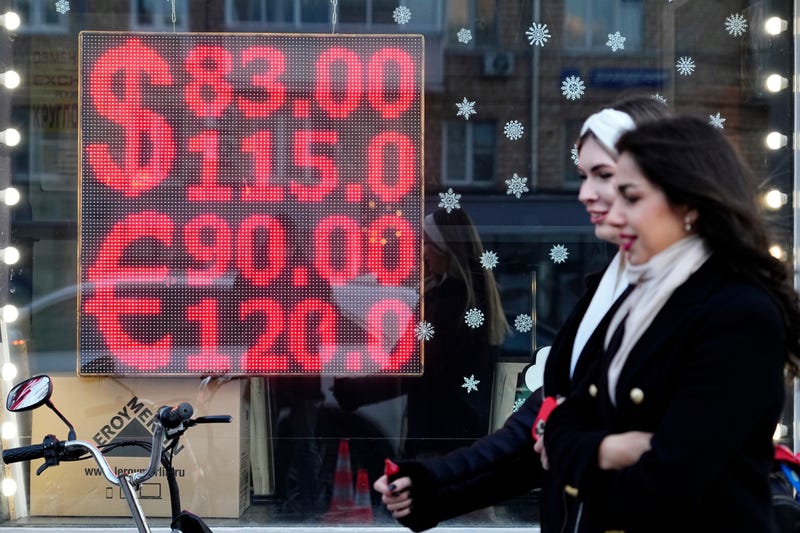 People walk past a currency exchange office screen displaying the exchange rates of U.S. Dollar and Euro to Russian Rubles in Moscow's downtown, Russia, on Feb. 28, 2022
