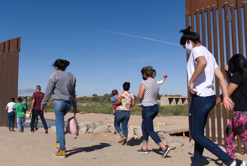 FILE - A group of Brazilian migrants make their way around a gap in the U.S.-Mexico border in Yuma, Ariz., seeking asylum in the United States after crossing over from Mexico, June 8, 2021. The Biden administration has unveiled new procedures to handle asylum claims at the U.S. southern border, hoping to decide cases in months instead of years. The rules empower asylum officers to grant or deny claims, an authority that has been limited to immigration judges for people arriving at the border with Mexico.