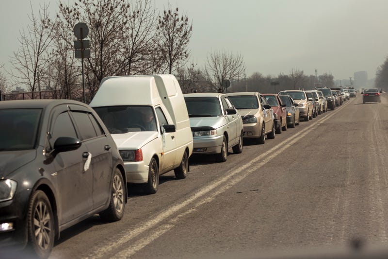 Local residents lineup in their cars to leave Mariupol for more peaceful place on the territory which is under the Government of the Donetsk People's Republic control, on the outskirts of Mariupol, Ukraine, Thursday, March 24, 2022