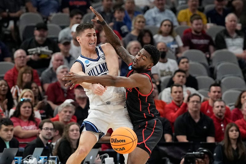 Villanova guard Collin Gillespie passes around Houston guard Jamal Shead during the first half of a college basketball game in the Elite Eight round of the NCAA tournament on Saturday, March 26, 2022, in San Antonio.