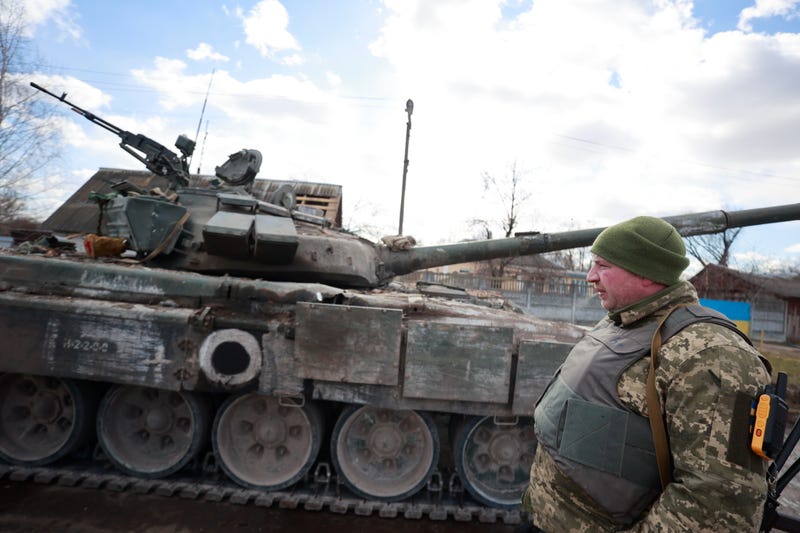 A Ukrainian serviceman stands next to a tank in a village of Lukyanivka, Kyiv region, Ukraine, Sunday, March 27, 2022