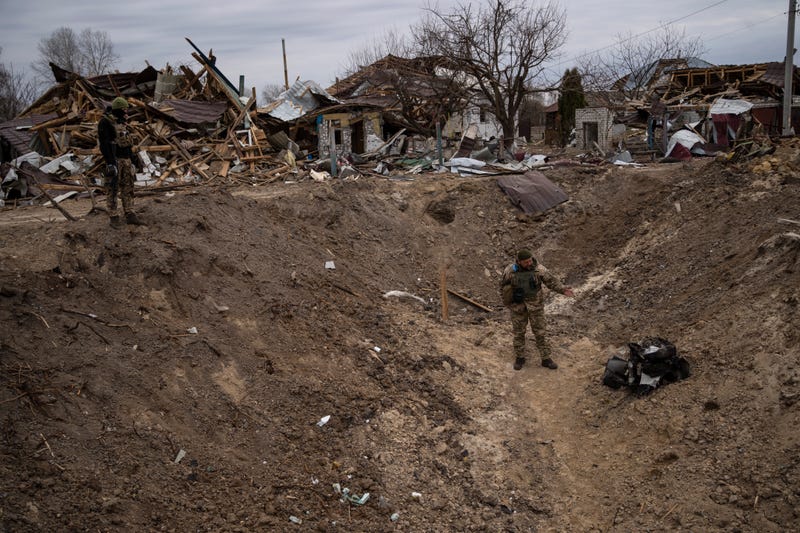 A soldier stands inside a crater made by a bomb near Brovary, on the outskirts of Kyiv, Ukraine, Monday, March 28, 2022