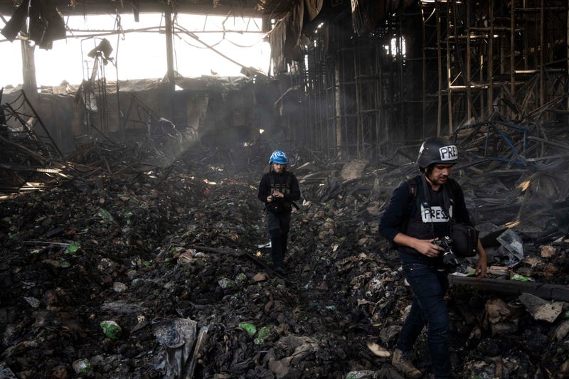 Journalists walk inside a destroyed warehouse for storing food, after an attack from Russia twelve days ago in Brovary, on the outskirts of Kyiv, Ukraine, Tuesday, March 29, 2022