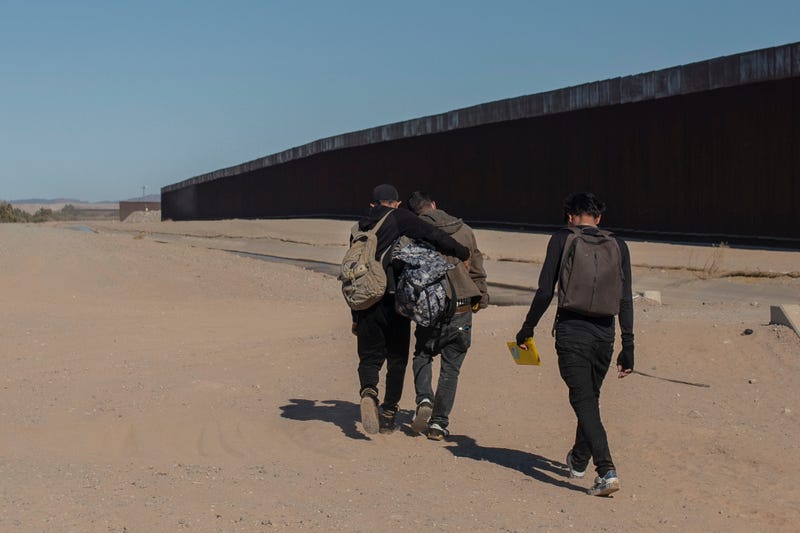 FILE - Nicaraguan migrants walk on the US-Mexico border, in Algodones, Baja California, Mexico, Dec. 2, 2021. The group walked into the U.S. and turned themselves over to the border patrol asking for asylum. The Biden administration has a draft plan to end sweeping asylum limits at the U.S.-Mexico border by May 23 that were put in place to prevent the spread of COVID-19, according to people familiar with the plans.