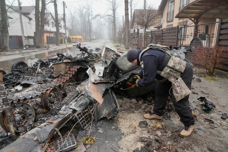 A Ukrainian soldier checks a destroyed Russian tank, in Irpin close to Kyiv, Ukraine, Friday, April 1, 2022