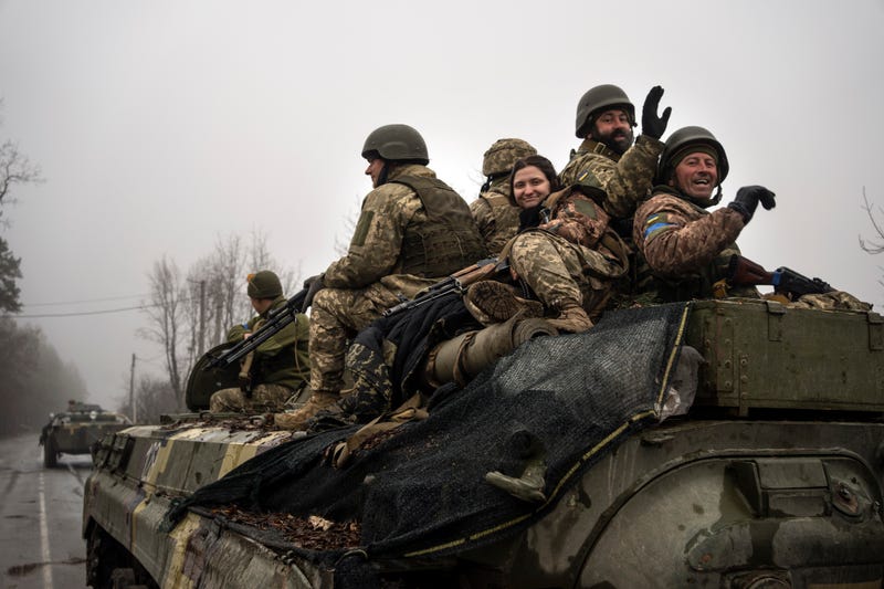 Ukrainian soldiers wave to reporters during a military sweep to search for possible remnants of Russian troops after their withdrawal from villages in the outskirts of Kyiv, Ukraine, Friday, April 1, 2022