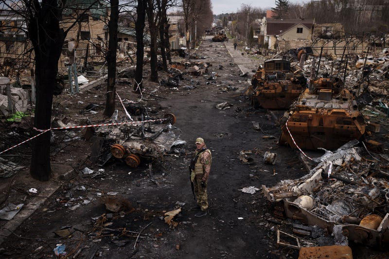A Ukrainian serviceman stands amid destroyed Russian tanks in Bucha, on the outskirts of Kyiv, Ukraine, Wednesday, April 6, 2022