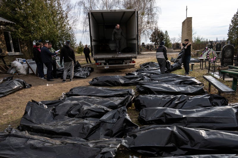 Cemetery workers load the corpses of civilians killed in Bucha into a truck, to be transported to the morgue, on the outskirts of Kyiv, Ukraine, Wednesday, April 6, 2022.  