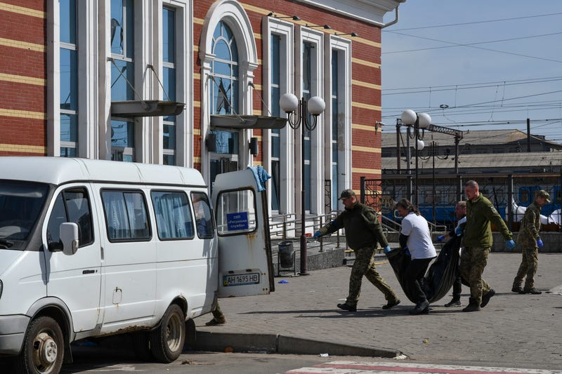 Ukrainian servicemen carry a body after Russian shelling at the railway station in Kramatorsk, Ukraine, Friday, April 8, 2022